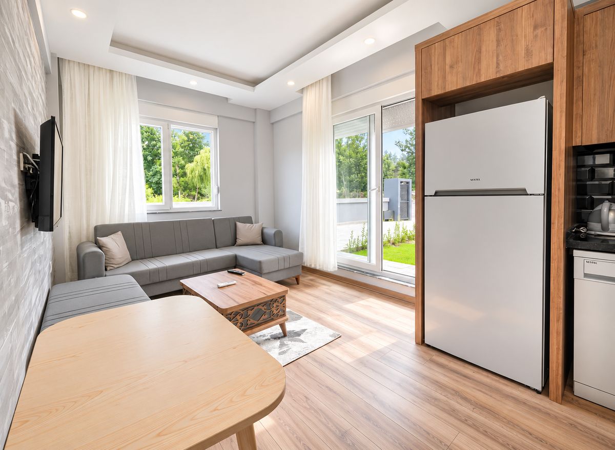 Living room and kitchen area with sofa, dining table and fridge
