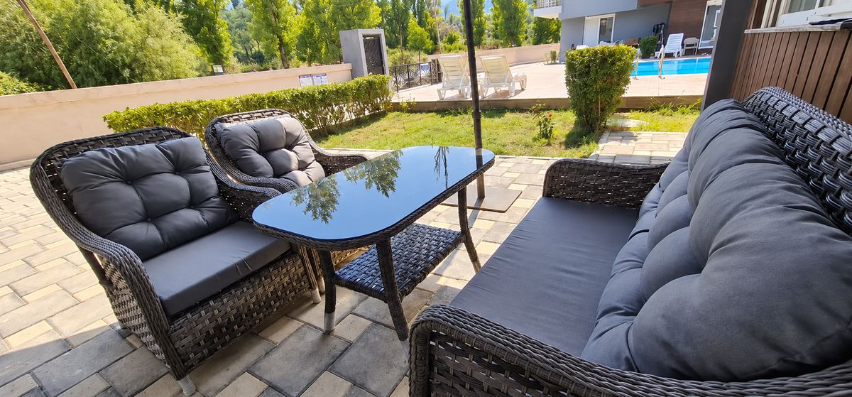 Rattan garden seating with cushions on a sunny terrace